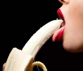 Eine Frau leckt lasziv an einer Banane und suggeriert somit Fellatio